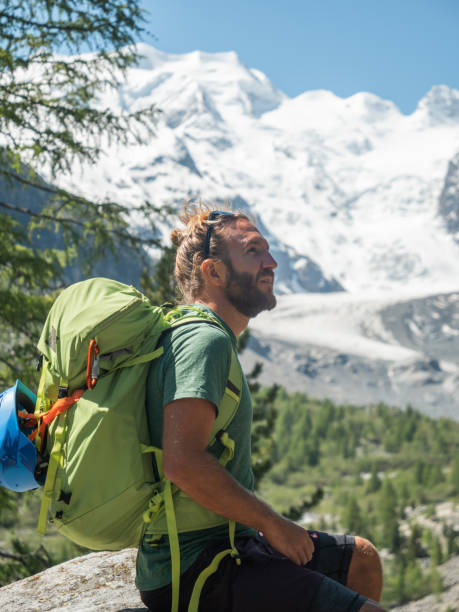 istock Male rock climber contemplates glacier view from top 1285969799
