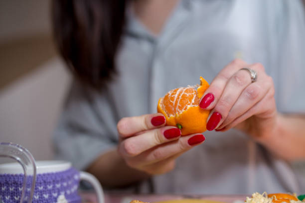 istock Female hands peel tangerine 1285970033