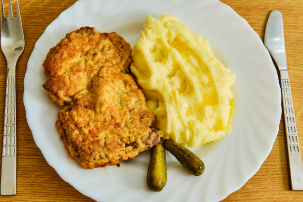 istock Tasty inside out roest beef schnitzel with mashed potatoes on white plate on wooden table with fork and knife 1285971235