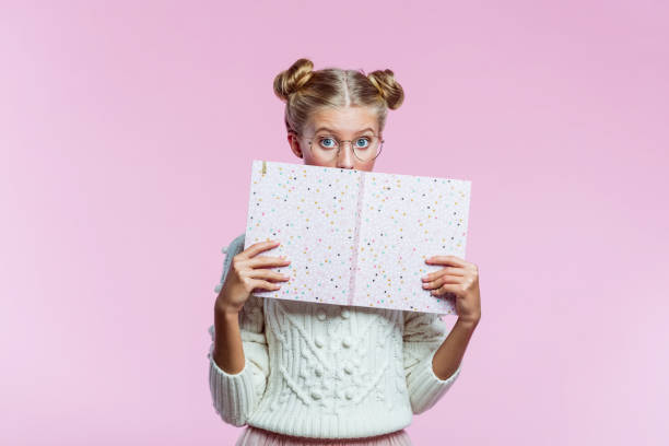 Beautiful teenege girl holding pink diary