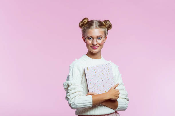 istock Beautiful teenege girl holding pink diary 1285971872