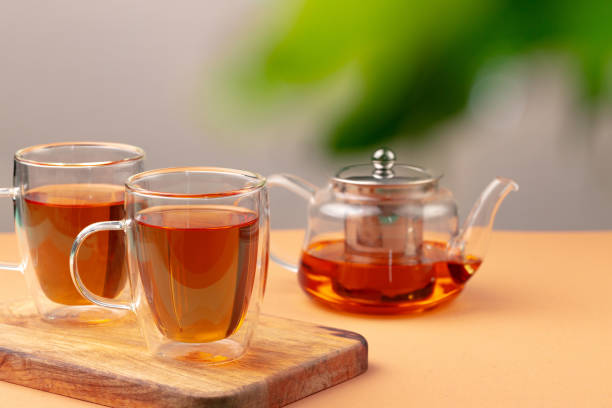 istock Glass teapot and two glass cups with tea 1285972354