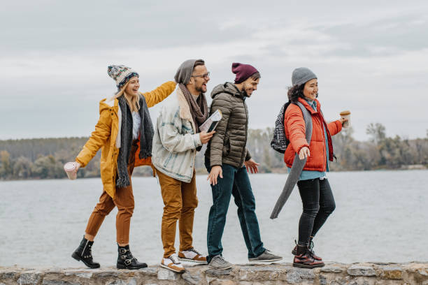 istock Four friends walking on the wall on the riverbank 1285973117