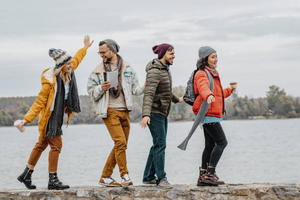istock Four friends walking on the wall on the riverbank 1285973373