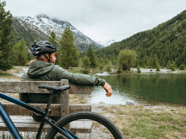 istock Mountain biker relaxes by lakeshore 1285973414