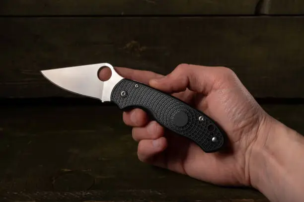 Photo of Compact little knife in hand. A knife with a lightweight handle. Knife in hand.