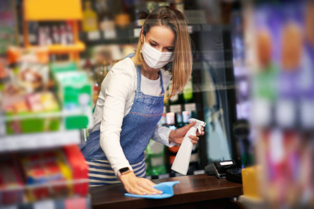Shop assistant disinfecting surfaces in grocery store Picture of shop assistant disinfecting surfaces in grocery store sold out photos stock pictures, royalty-free photos & images