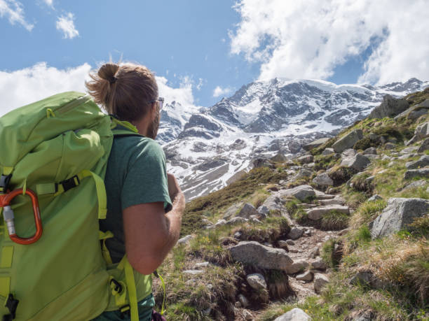 istock Mountaineer looks up at peak 1285973958