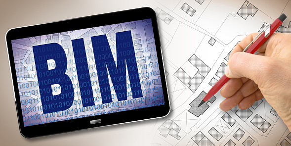 Building Information Modeling (BIM), a new way of architecture designing - concept image with a 3D render of a digital tablet and an imaginary city map on device screen.
