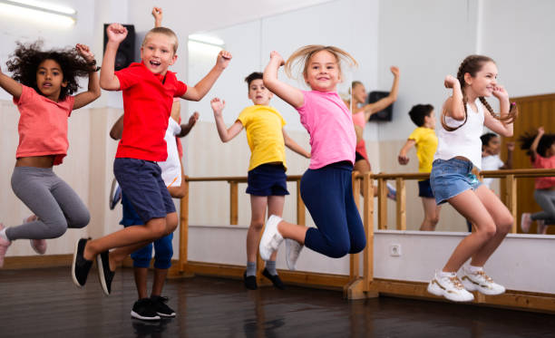 istock Happy sporty kids jumping together in dance studio 1285974115