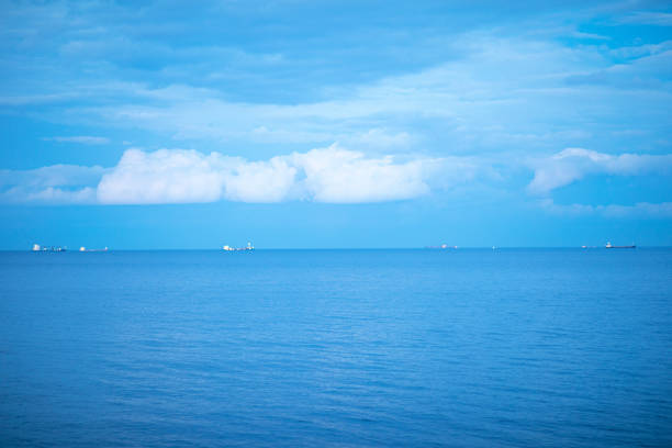 Calm blue sea with ships in the background.