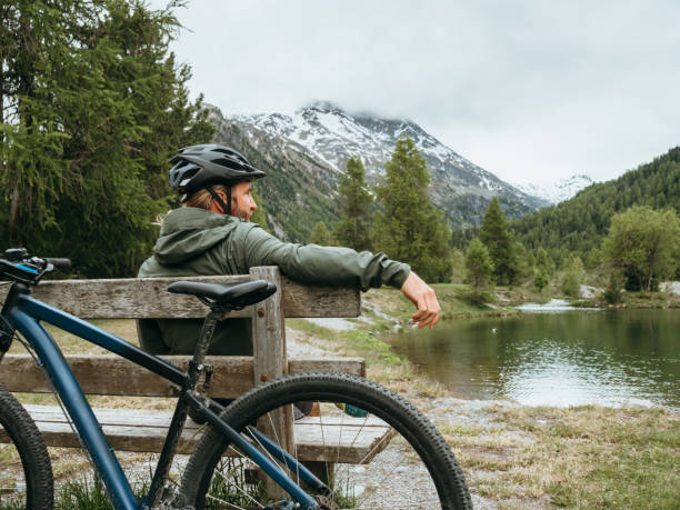 istock Mountain biker relaxes by lakeshore 1285975679