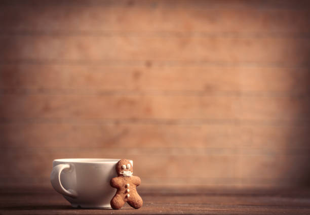 istock Gingerbread man in mask and cup on a wooden table 1285980041