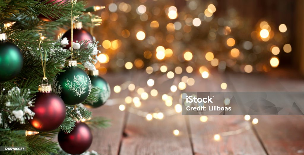Albero di Natale, ornamenti rossi e verdi contro uno sfondo luci sfocalizzato - Foto stock royalty-free di Natale