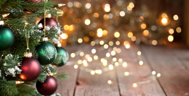 kerstboom, rode en groene ornamenten tegen een onscherpe achtergrond van lichten - kerstmis stockfoto's en -beelden