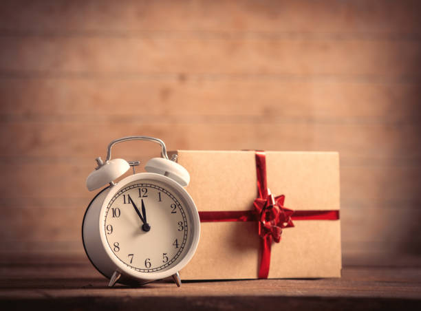 istock holiday gift and alarm clock on wooden table and background 1285980133