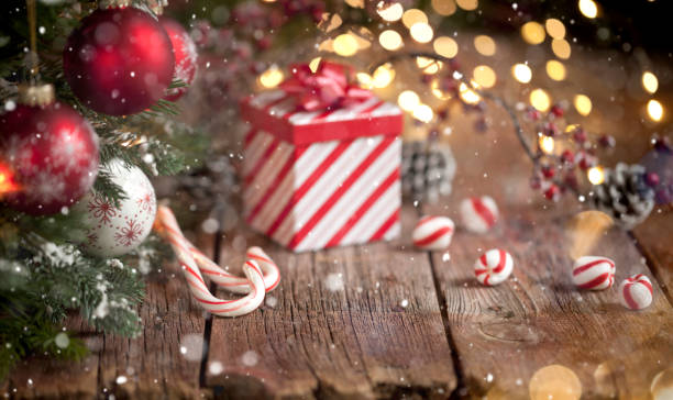 Christmas Tree, Gift and Candy Cane Background Christmas tree with red and white baubles, candy canes and a  striped gift box on an old wood background peppermints stock pictures, royalty-free photos & images
