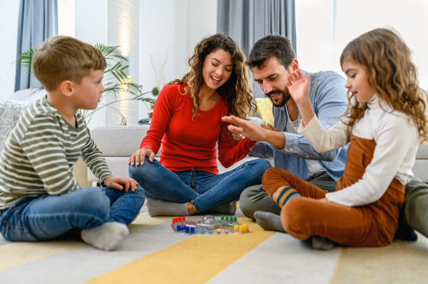istock Cheerful parents playing board game with their children. 1285983929