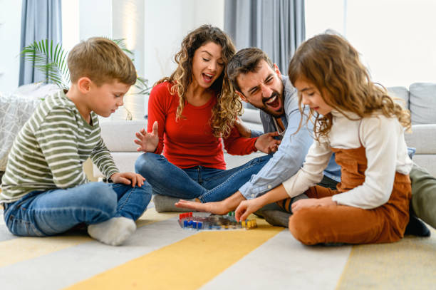 istock Cheerful parents playing board game with their children. 1285985223
