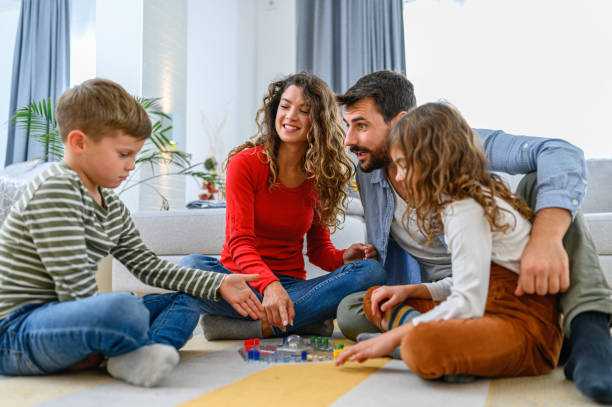 istock Cheerful parents playing board game with their children. 1285987134