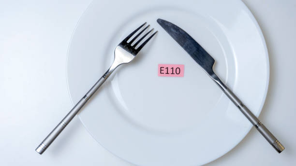 istock Harmful food additives. Knives, fork, plate. On the plate there are several table with the E-supplement code. 1285989474