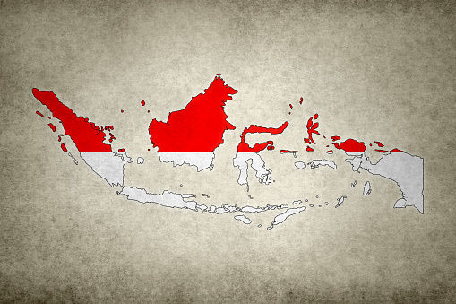 Grunge map of Indonesia with its flag printed within its border on an old paper.