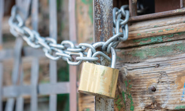 istock Heavy metal padlock with chain closeup on an entrance gate. 1285990414