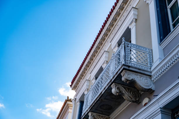 Neoclassical building facade with balcony detail, blue sky background, Plaka, Athens Greece. Low angle view