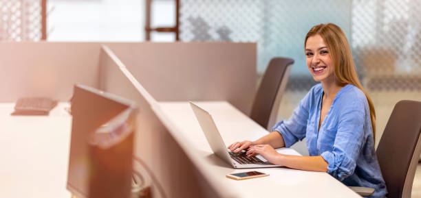 istock Young businesswoman using laptop in a modern office 1285990444