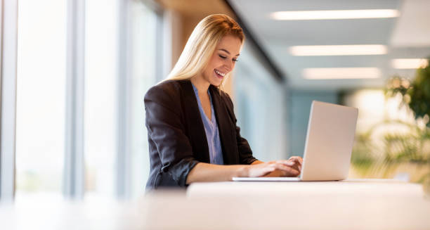 istock Young businesswoman using laptop in a modern office 1285991114