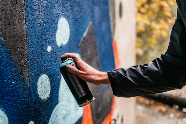 istock Man painting graffiti on wall 1285991199