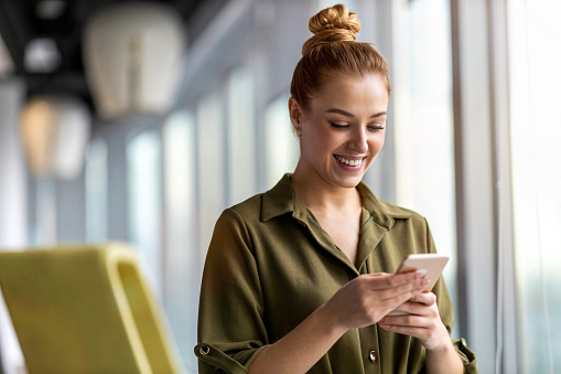 Young businesswoman using a smartphone in a modern office