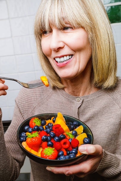 istock Attractive senior woman with fruit bowl 1285993786