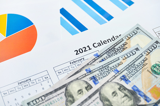 Successful 2021 year in generating profits for businesses with dollars on paper charts.