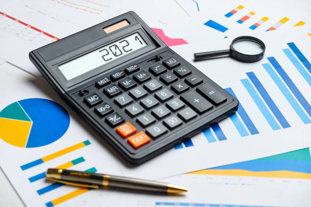 istock Financial concept in 2021 on a calculator and graphs 1285994861