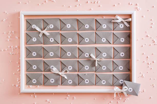 calendario de adviento ya hecho a partir de sobres de cartón gris en un marco blanco sobre una mesa en decoraciones navideñas - advent calendar advent christmas childhood fotografías e imágenes de stock