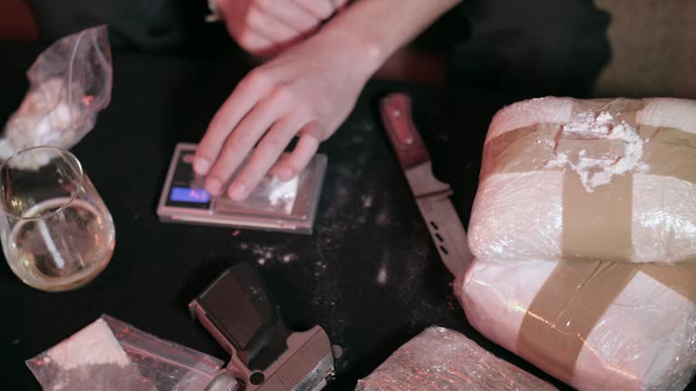 Drugs dealer preparing dose of danger drugs in dark room.