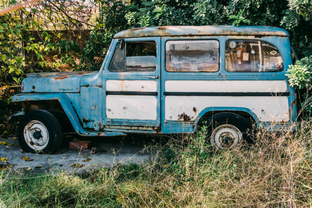 Old abandoned van in a house garden surrounded by grass