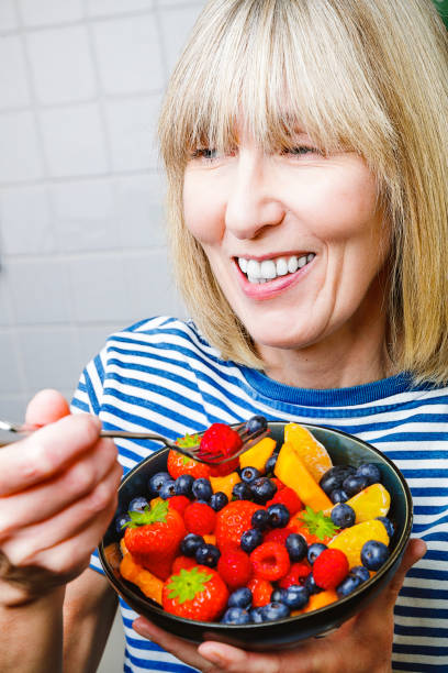 istock Attractive senior woman with fruit bowl 1286003251