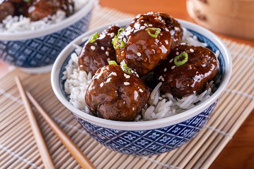 A bowl of delicious honey garlic meatballs with steamed rice.