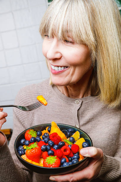 istock Attractive senior woman with fruit bowl 1286004967