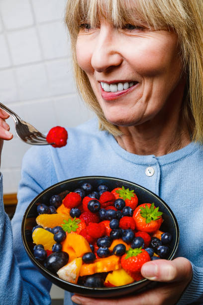 istock Attractive senior woman with fruit bowl 1286005487