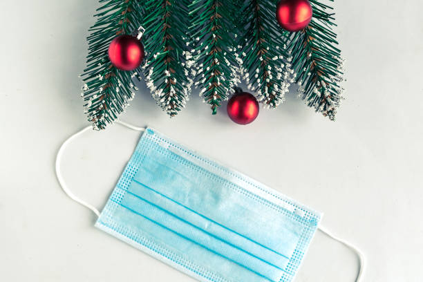 istock christmas tree branches and face mask on white background, coronavirus Christmas concept 1286006193