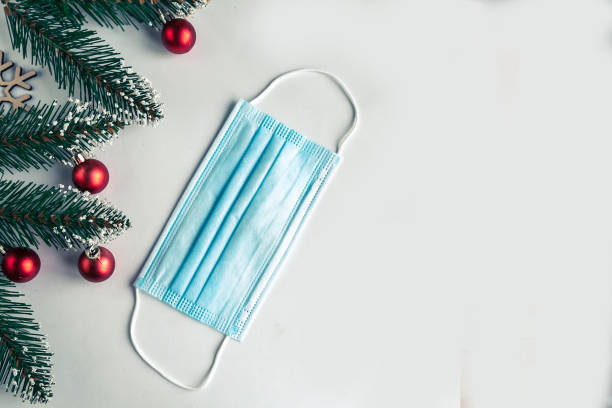 istock christmas tree branches and face mask on white background, coronavirus Christmas concept 1286006300