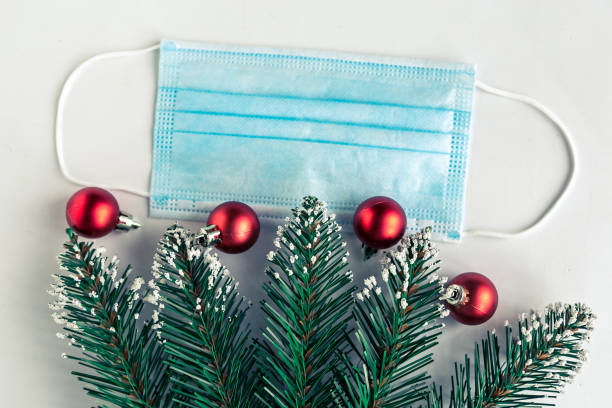 istock christmas tree branches and face mask on white background, coronavirus Christmas concept 1286006424
