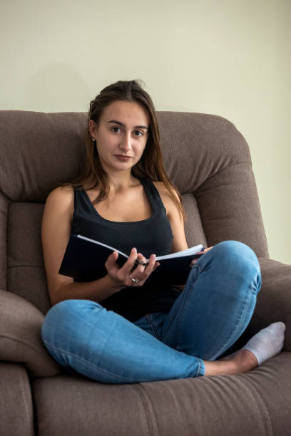 istock woman sitting in comfy sofa reading diary book enjoy free time 1286006560