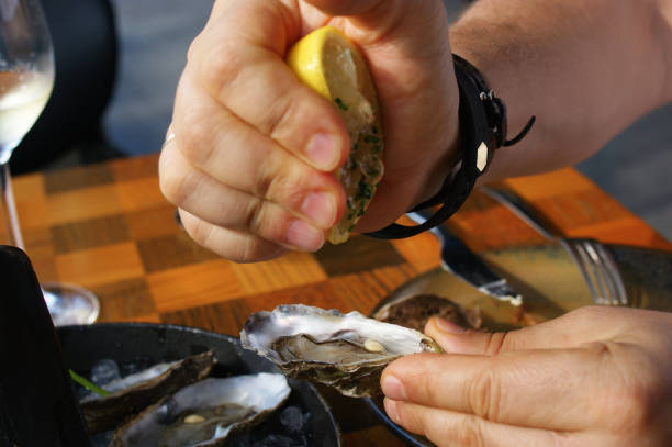 istock hand squeezes lemon juice into fresh oyster. fresh oysters in a restaurant 1286006724