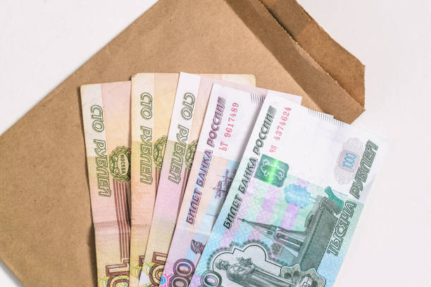 istock Russian money and a cardboard envelope. Banknotes isolated on white. Top view, flat lay 1286007756