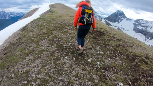 istock Young woman hikes up mountain ridge on a stormy day 1286010761