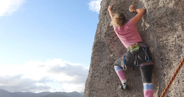 istock Young woman climbs steep rock face 1286012191